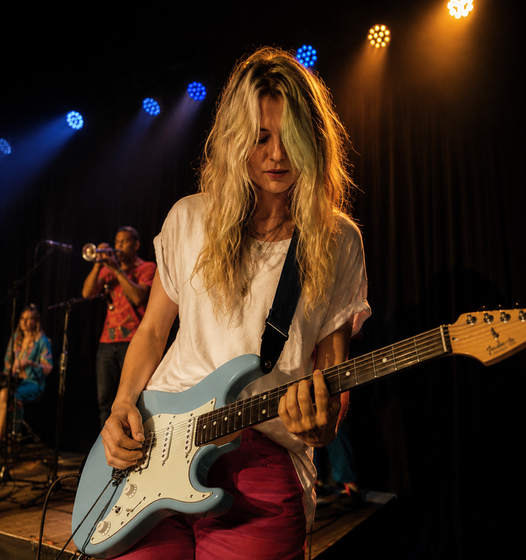 Guitarist performing under stage lights